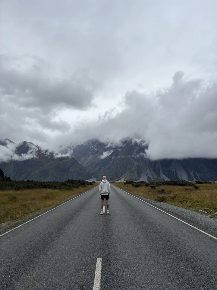 A lone figure on an open mountain road
